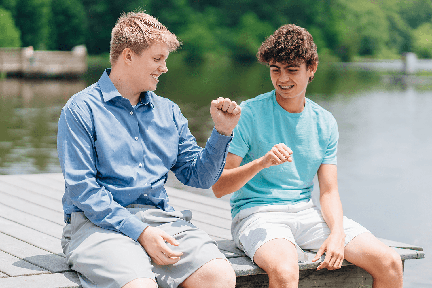two teens sitting on dock